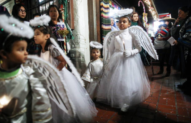 Children march dressed as angels during the annual Las Posadas Christmas Eve procession
